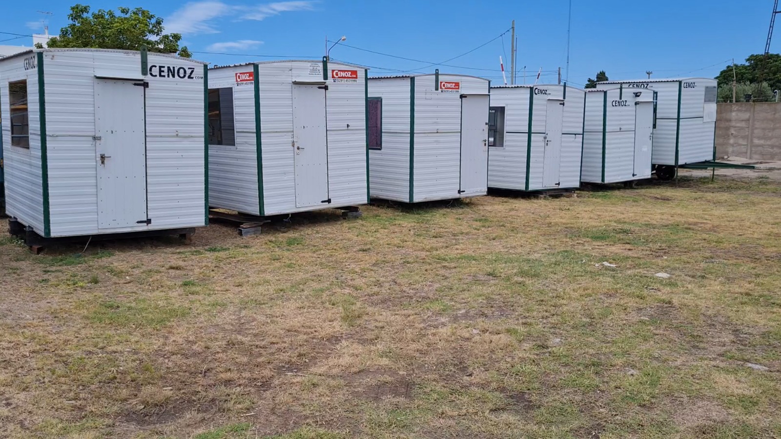 Módulos tradicionales blancos exhibidos en fila sobre césped