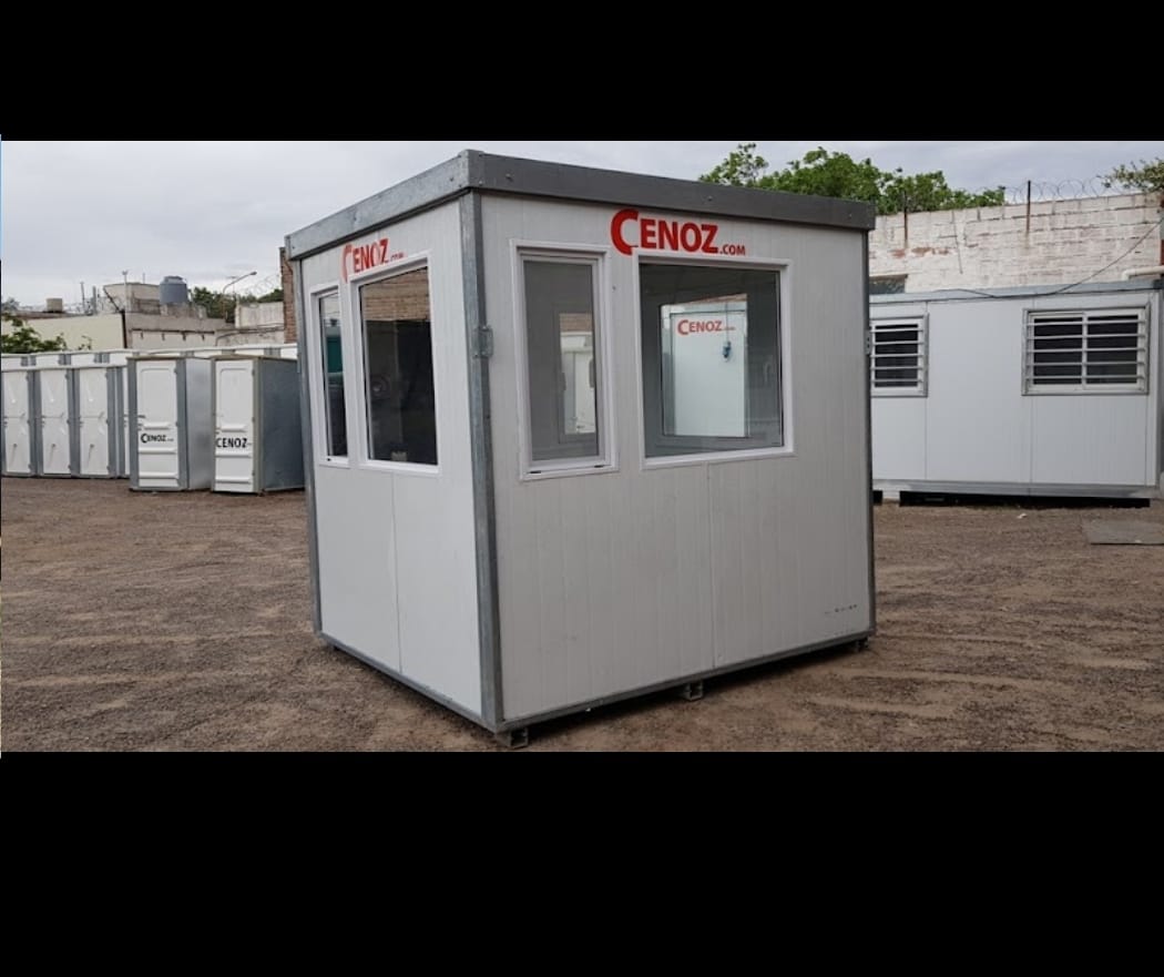 Cabina modular portátil blanca con ventanas perimetrales exhibida en un predio