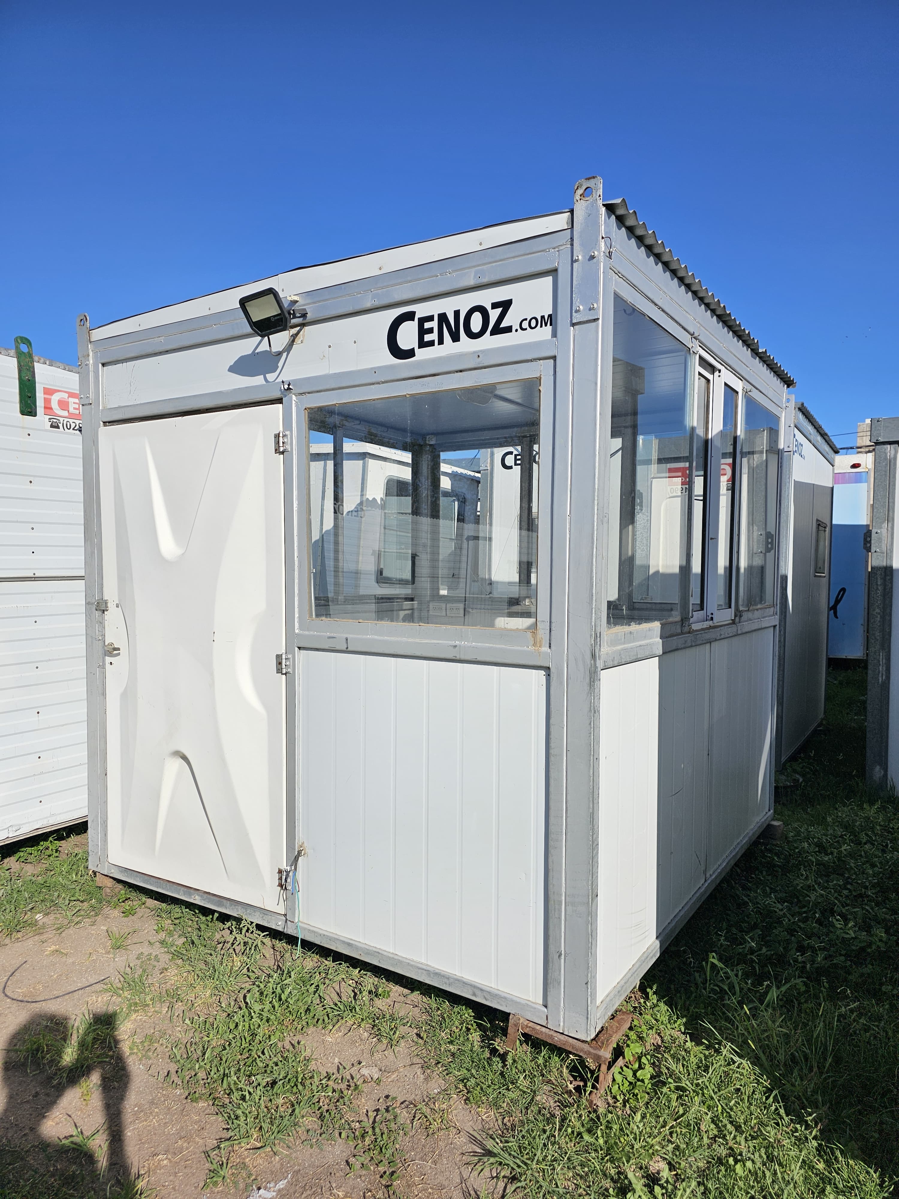 Módulo portátil habitacional compacto con frente vidriado y puerta lateral
