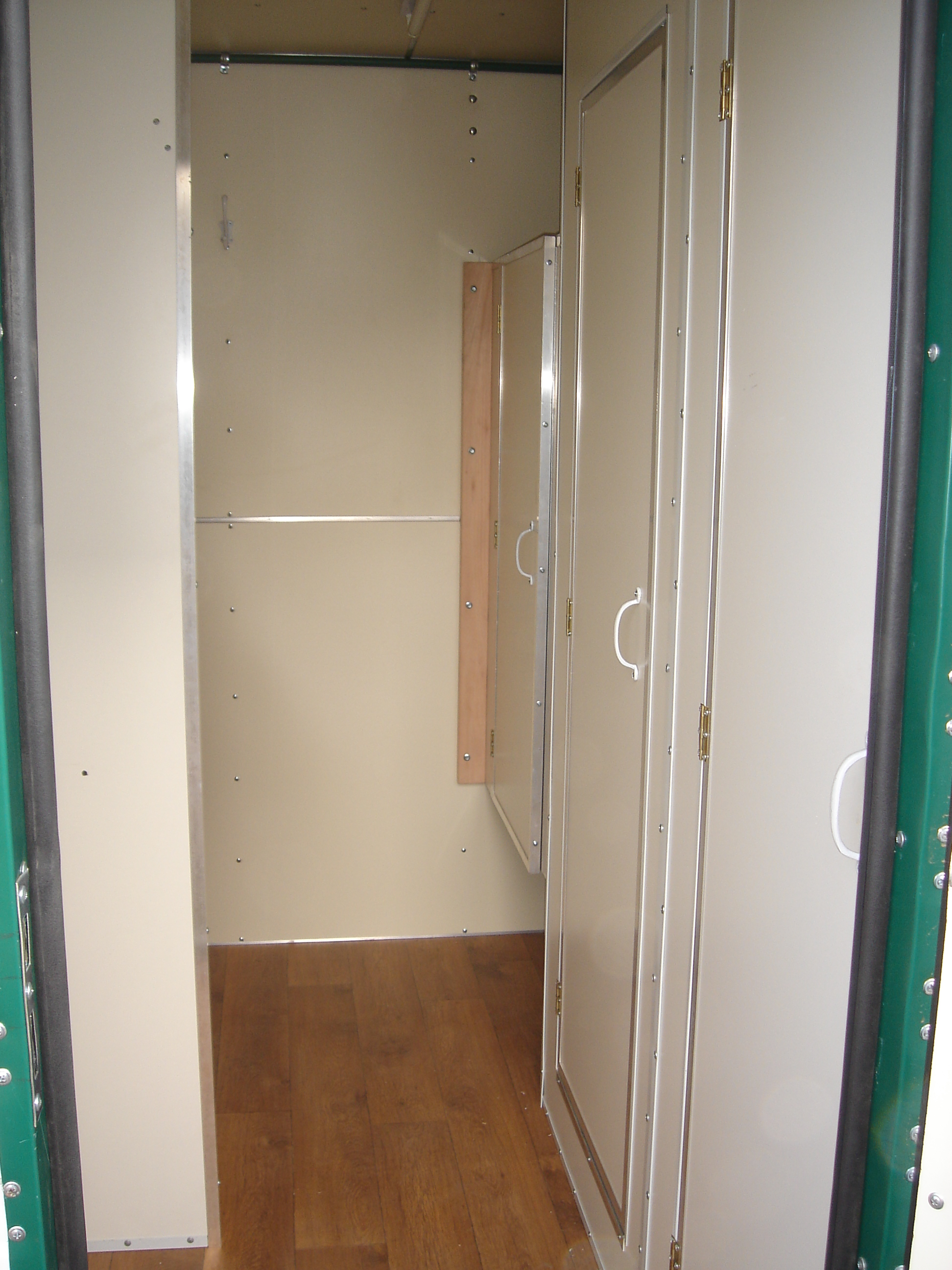 Interior del módulo tradicional con piso símil madera, puerta interna y mueble lateral